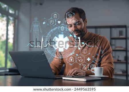 Thoughtful businessman in casual wear typing on laptop at office workplace. Concept of insurance company, help, business, internet surfing, information technology. Medical icons hologram