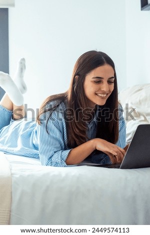 One young lady having relax surfing the net alone at home laying on bed in bedroom. Traveler business modern online people working in hotel room. One woman using computer laptop with relaxation