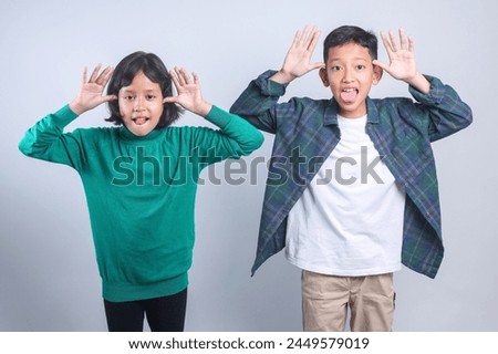 Two Young Kids Showing Funny Silly Face Make a Joke Isolated on White Background