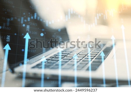 Close up of laptop computer at desk with growing blue vertical arrows and candlestick forex chart on blurry index grid background. Economic growth and increase concept. Double exposure