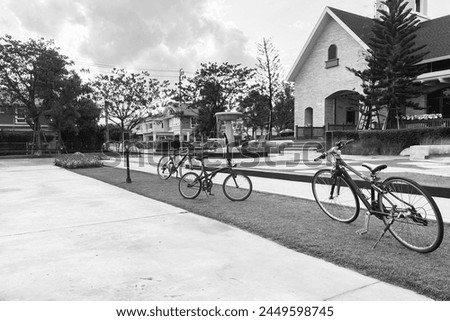 Black and white image of outdoor open space suburb small town with bicycles, classic buildings, fountain and park show peaceful and loneliness atmosphere.
