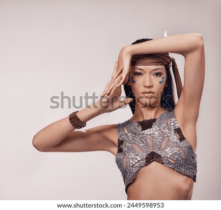 Portrait, woman and Native American makeup in studio with warrior culture, confidence and tribe style. Indigenous fashion, face paint and girl in First Nations clothes on white background with pride