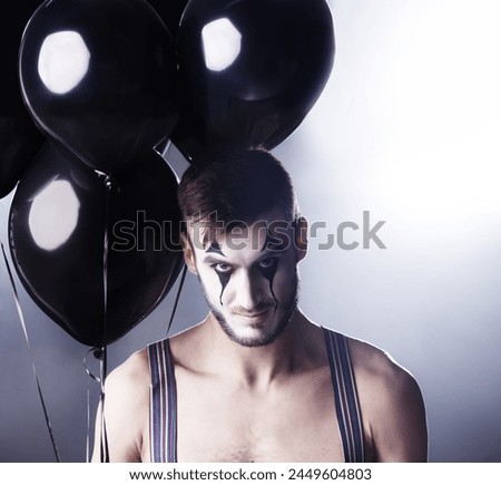 Man, circus and topless for theatre performance on dark background with light for stage, creative and entertainment. Portrait, mime and performer with balloons, face paint and tattoo for creativity