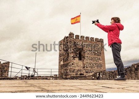 Tourist woman with camera taking travel picture on Sohail Castle in Fuengirola, Malaga Spain. Tourist attraction. Holidays on Costa del Sol.