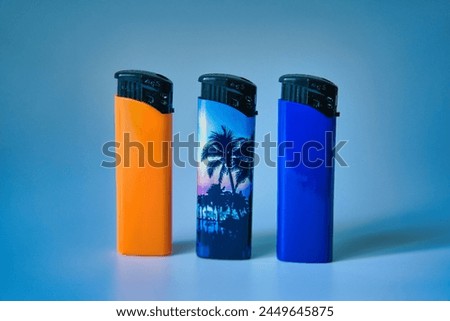 three lighters, in different colors Royalty-Free Stock Photo #2449645875