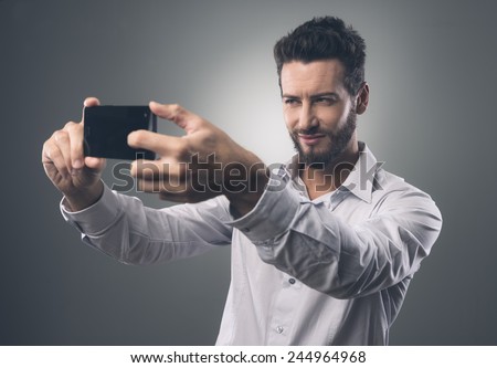 Cool handsome man taking self portraits with his smartphone