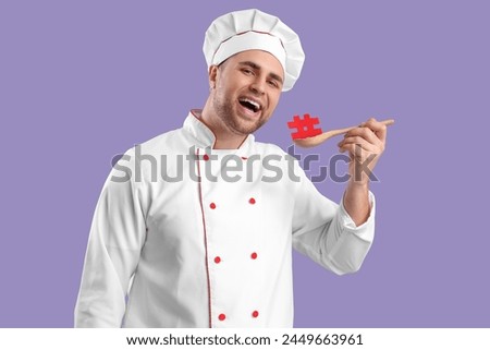Male chef with spoon and hashtag on lilac background