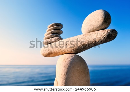 Balancing of white pebbles on the top of stone Royalty-Free Stock Photo #244966906