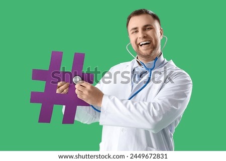 Male doctor with stethoscope and hashtag on green background