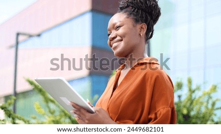 Happy businesswoman using tablet outside