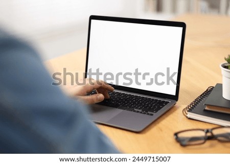 Young man watching webinar at table indoors, closeup