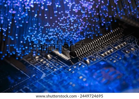 Macro photograph of a printed circuit board with a processor and optical fibers illuminating the board Royalty-Free Stock Photo #2449724695