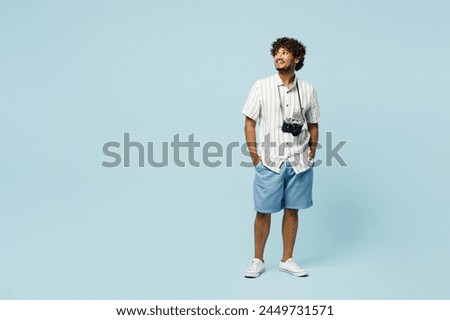 Full body traveler Indian man wears white casual clothes look aside on area isolated on plain blue background. Tourist travel abroad in free spare time rest getaway. Air flight trip journey concept Royalty-Free Stock Photo #2449731571