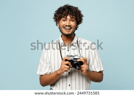 Traveler Indian man wear white casual clothes use camera taking photo picture isolated on plain blue background. Tourist travel abroad in free spare time rest getaway. Air flight trip journey concept