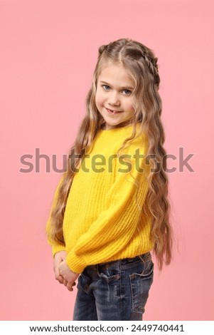 Cute little girl with braided hair on pink background