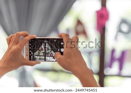 A man is taking pictures with a mobile phone in his hand