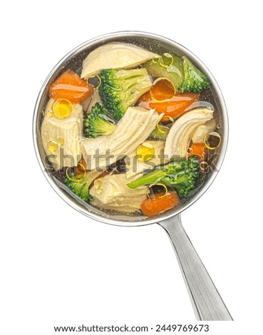 Ladle with chicken soup with vegetables isolated on white background, top view