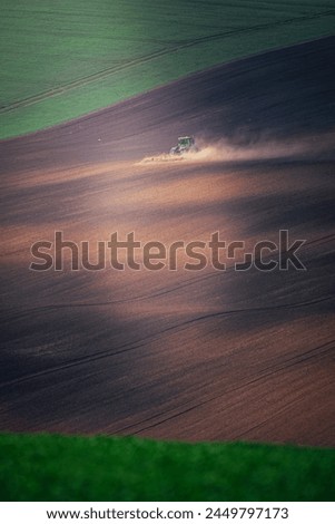 Tractor during autumn or spring work in the fields of South Moravia at sunset