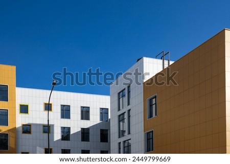 Fragment of a complex of buildings of variable storey with windows of different sizes for articles, blogs, sites on the construction, architectural theme. Copy space
