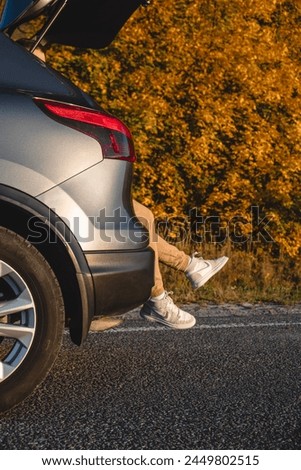 In the trunk of an automobile, there is a picture of a man's legs jutting out. rest after a long trip