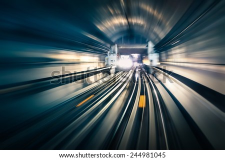 Subway tunnel with blurred light tracks with arriving train in the opposite direction - Concept of modern metro underground transport and connection speed Royalty-Free Stock Photo #244981045