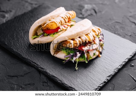 Two chicken shawarma wraps with fresh veggies and creamy sauce
