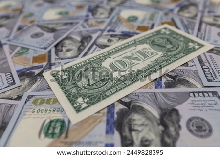 US 1 dollar banknote isolated on US 100 dollar banknotes