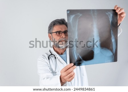 Doctor examining chest x-ray film of patient at hospital. Lung radiography concept. radiology doctor examining at chest x ray film of patient at hospital room. Male doctor looking at the x-ray picture