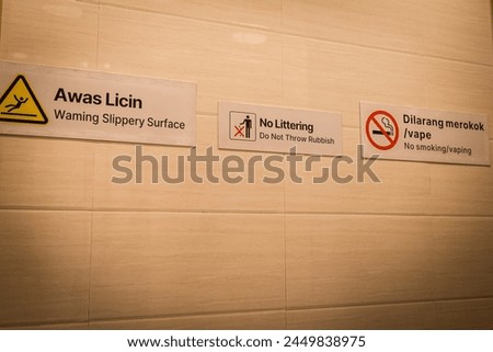 Several warning signs are displayed on the walls of public toilets explaining "be careful of slippery floors", "no littering" and "no smoking".