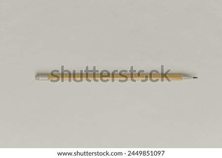 A graphite pencil with an eraser lies on white paper. Royalty-Free Stock Photo #2449851097