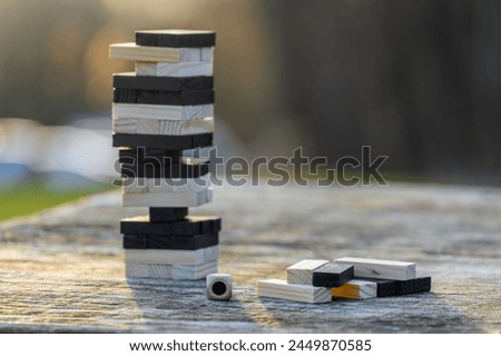 Peaceful rest in nature in sunny weather. The game "Jenga", "Wooden tower" against the background of nature. Concentration, calmness, choice, decision-making. High quality photo