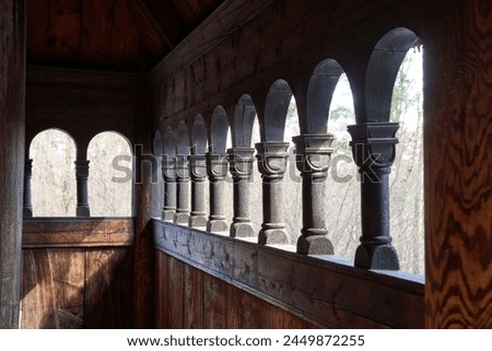 Norwegian wooden stave church exterior hallway with carved columns Royalty-Free Stock Photo #2449872255