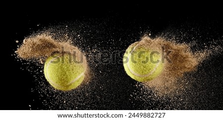 Two flying green tennis balls with sand explosion on black background
