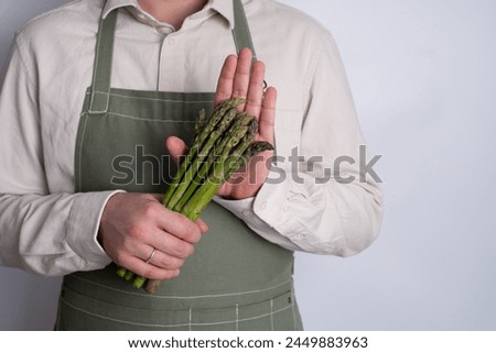 Green asparagus in the hands of a men. Bunch of ripe fresh asparagus. Healthy organic food. Cooking in home. Natural vitamins, raw ingredient for eating. Handpicked bio asparagus Royalty-Free Stock Photo #2449883963