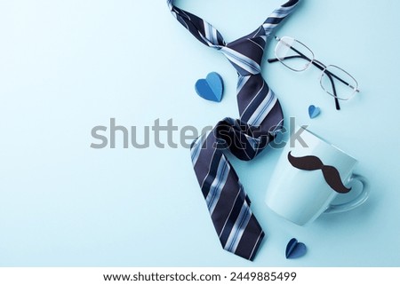 Stylish father's day setup with tie and eyeglasses. Flat lay of accessories on a light blue background with copy space