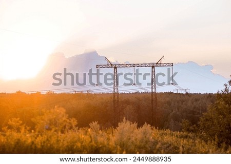 Power transmission lines  on steel supports against the background of the evening sunset sky. Royalty-Free Stock Photo #2449888935