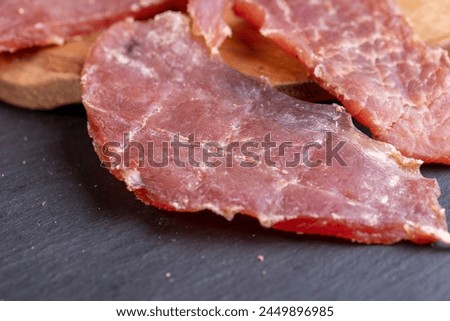 dried pork meat with spices and salt on the table, dry pork meat with salt and spices for flavor for long-term storage Royalty-Free Stock Photo #2449896985