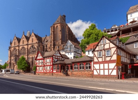 Medieval street with traditional half-timbered houses and University Church, Marburg an der Lahn, Germany Royalty-Free Stock Photo #2449928263