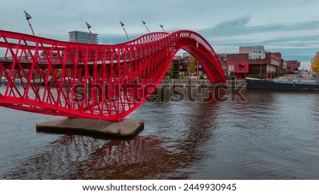 Aerial drone view of modern footbridge Python Bridge at Eastern Docklands neighborhood of Amsterdam Netherlands. 