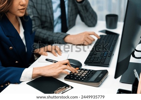 Cropped hands businessman with coworker calculating with calculator manual's financial and accounting report on computer database annual asset report, analyzing expenses and revenue company. Infobahn. Royalty-Free Stock Photo #2449935779