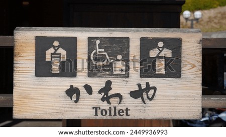 Restroom sign on a toilet door,Kimono and Yukata natural wood color background.The toilet sign,WC symbol. Both Japanese and English language.                               
