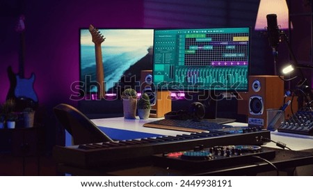 Empty studio at home equipped with mixing soundboard panel and other musical instruments, music industry recording. Modern space with electronic controls and daw software on pc. Camera A. Royalty-Free Stock Photo #2449938191