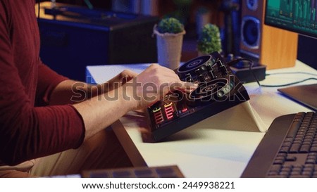 Music producer mixing individual tracks into a stereo in home studio, artist adjusting levels, panning and special effects to achieve a balanced audio. Musician does acoustical engineering. Camera A.