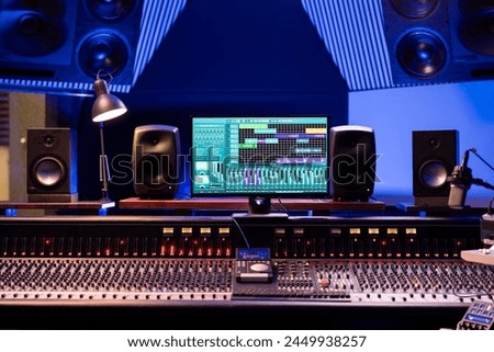 Empty professional studio used in music industry for producing tracks, mixing console and technical equipment in control room. Electronic panel board with sliders and buttons, daw software.