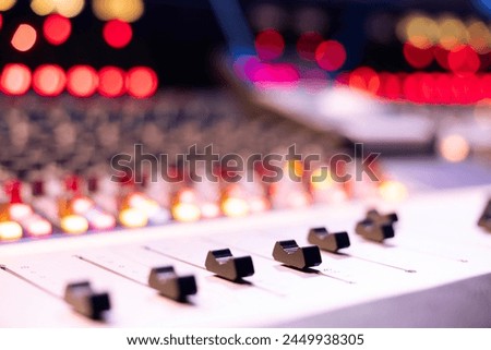 Motorized faders and sliders used in music production industry, soundboard pads station for editing and mixing tracks. Empty control room in professional studio, mix and master equipment. Close up. Royalty-Free Stock Photo #2449938305