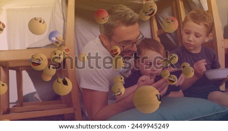 Image of falling emoji over happy caucasian family spending time together. childrens day concept digitally generated image.