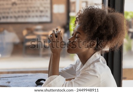 Portrait young black woman curly hair tourist woman looking at camera and siting in cafe