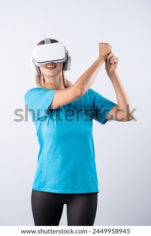 Caucasian girl playing golf and moving gesture by using VR glasses. Happy sport gamer with casual cloth playing game while wearing visual reality headset and standing at pink background. Contraption.