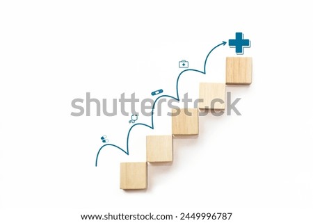 Wooden block stacking as step stair with arrow rising on white background and medical icons on the top. Health care, health insurance and treatment concept.