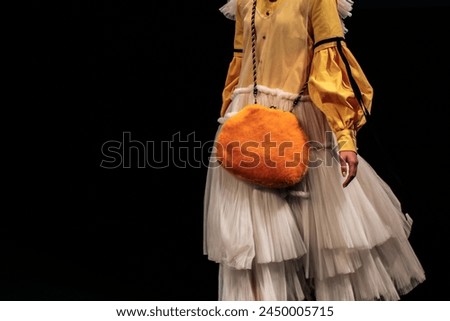 Cute children's white yellow dress and fluffy furry handbag. Elegant fashion for girls